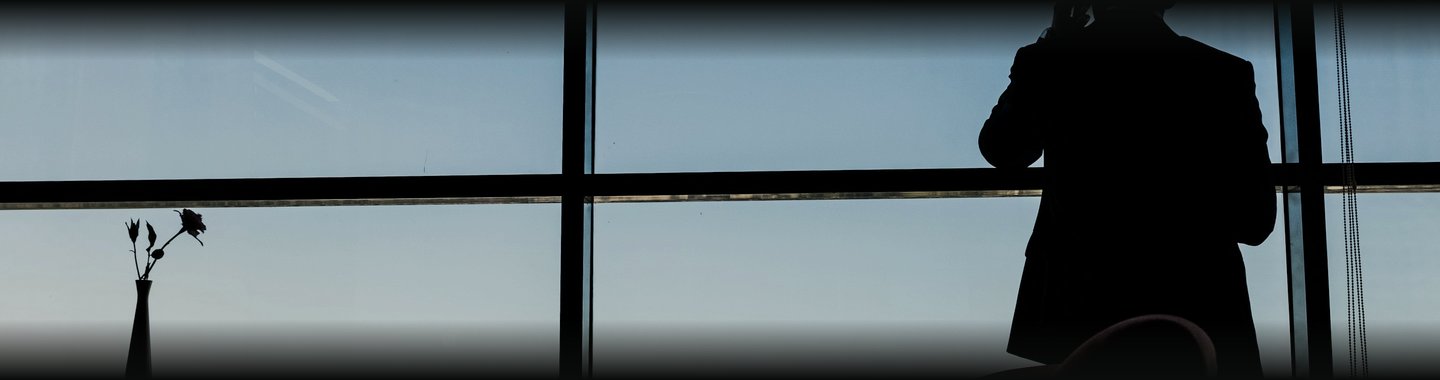 A man on a call by a Dubai window